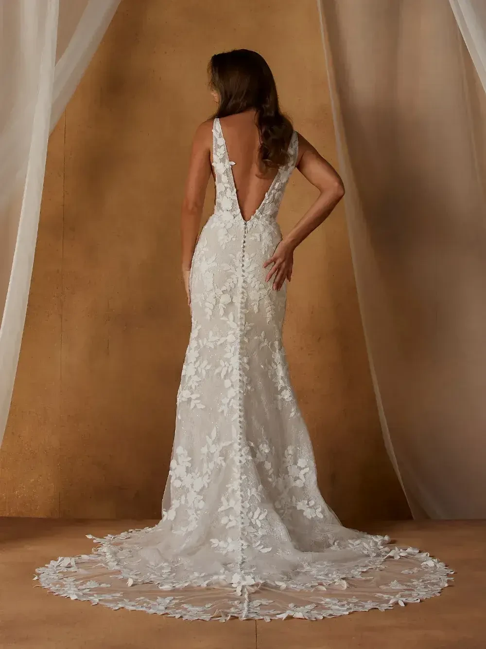 model is wearing a sleeveless lace bridal gown