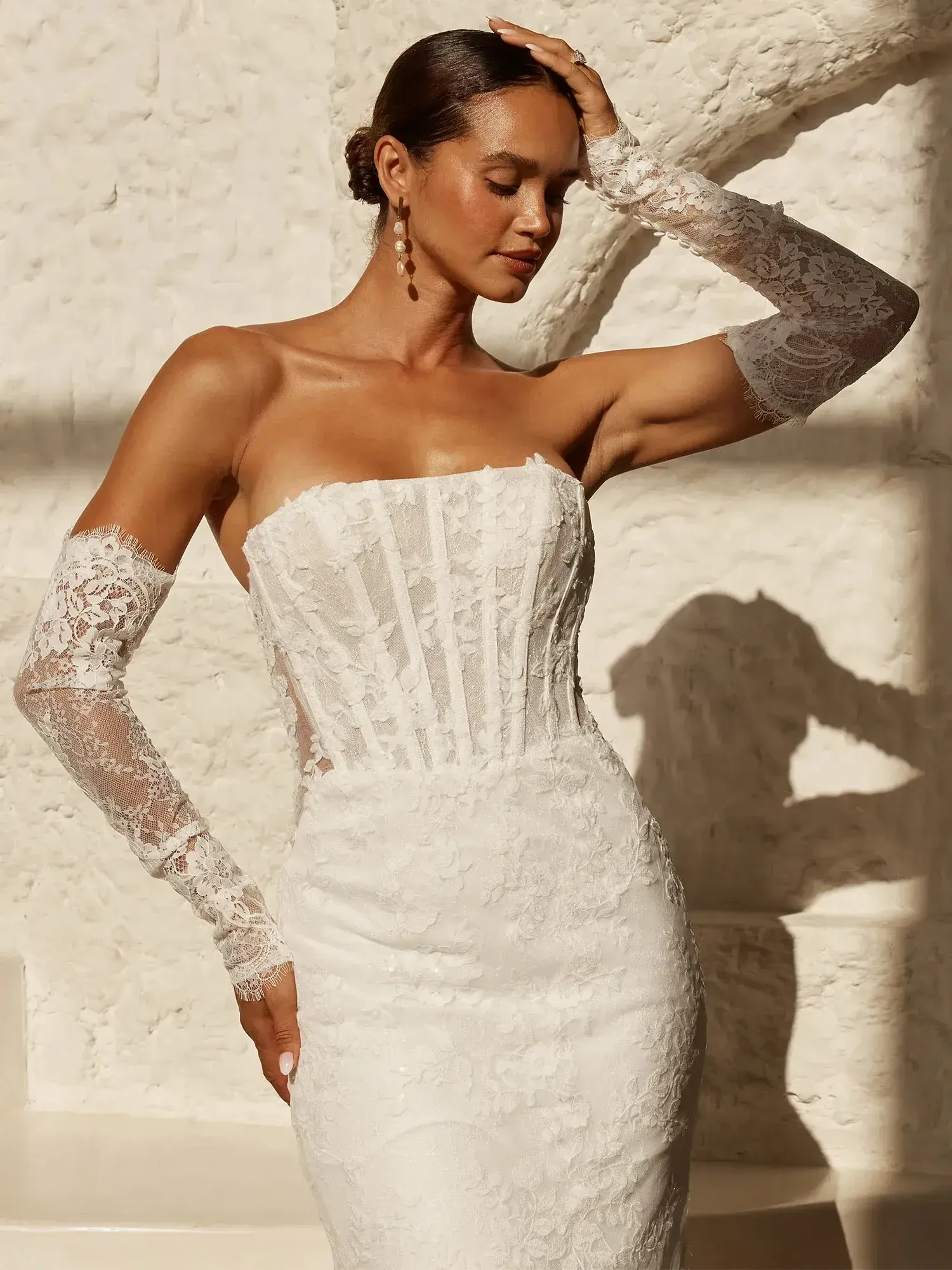 model is wearing a fitted lace wedding gown