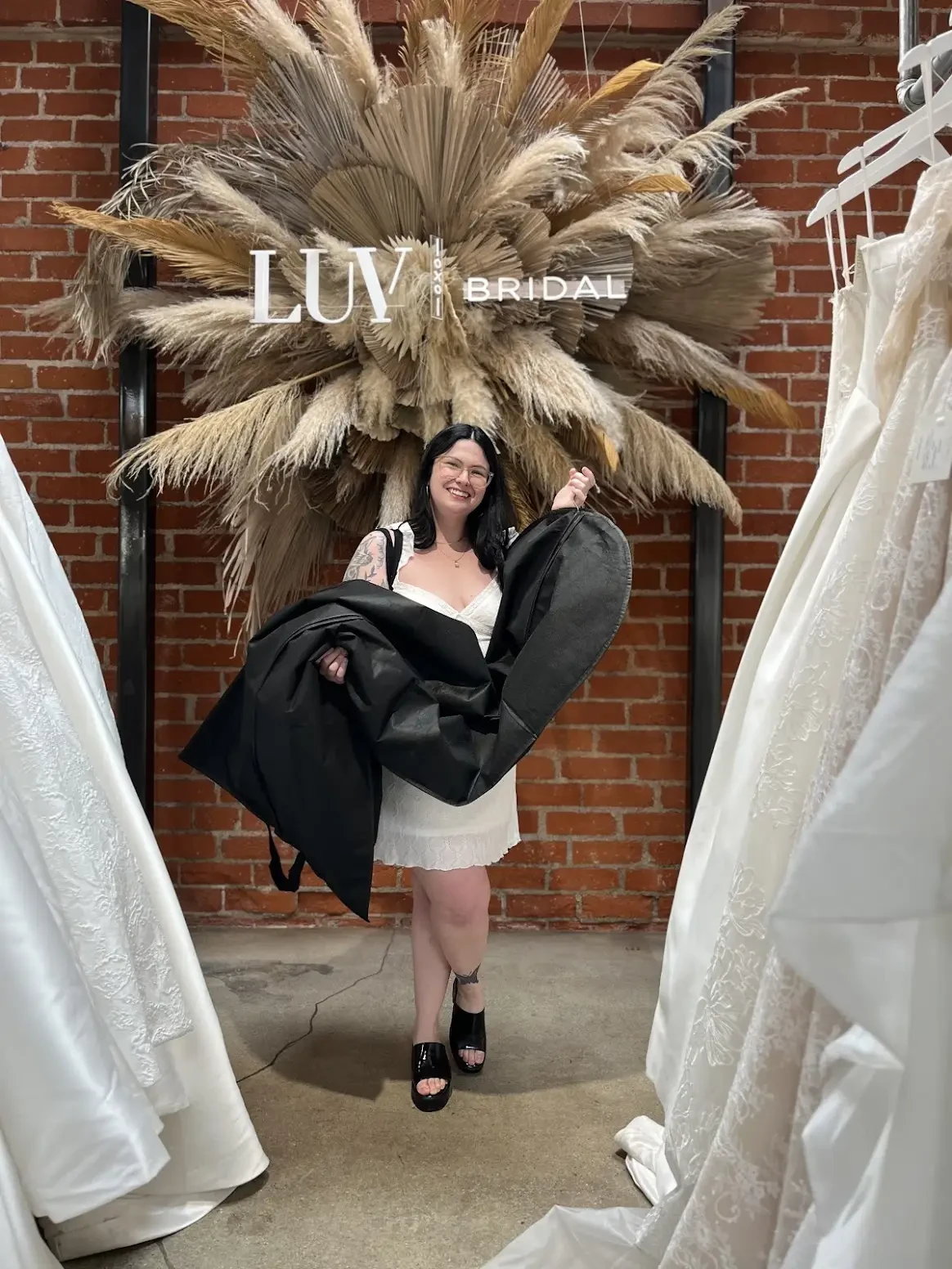 Our client holding a new bridal dress